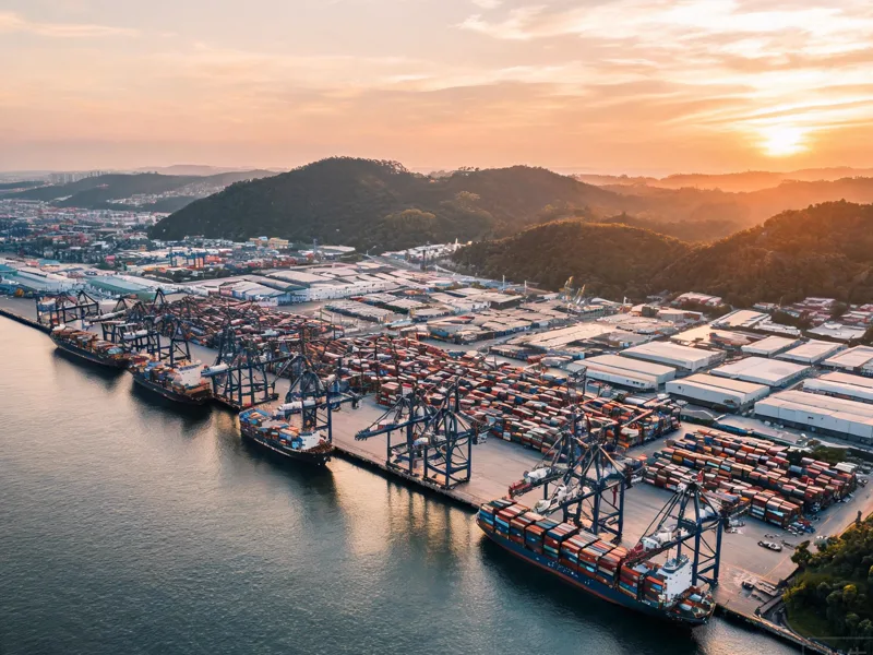 Aerial view of the Port of Santos in Brazil with container cranes and cargo ships at sunset